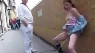 Online film piss, crazy girl walking down the street among the numerous passers