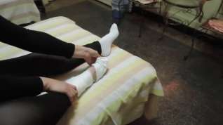 Online film Woman takes off white sock to reveal her bandaged ankle