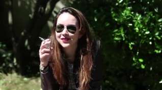 Online film Beautiful brunette smoking in a park