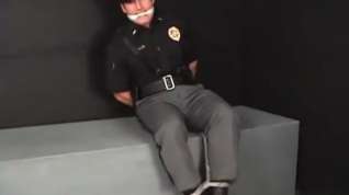 Online film Handsome young policeman cuffed gagged and struggling.