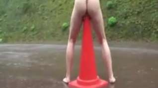 Online film Girl sitting on signaling cone on the road