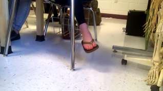 Online film Girl dangling flip flops in class